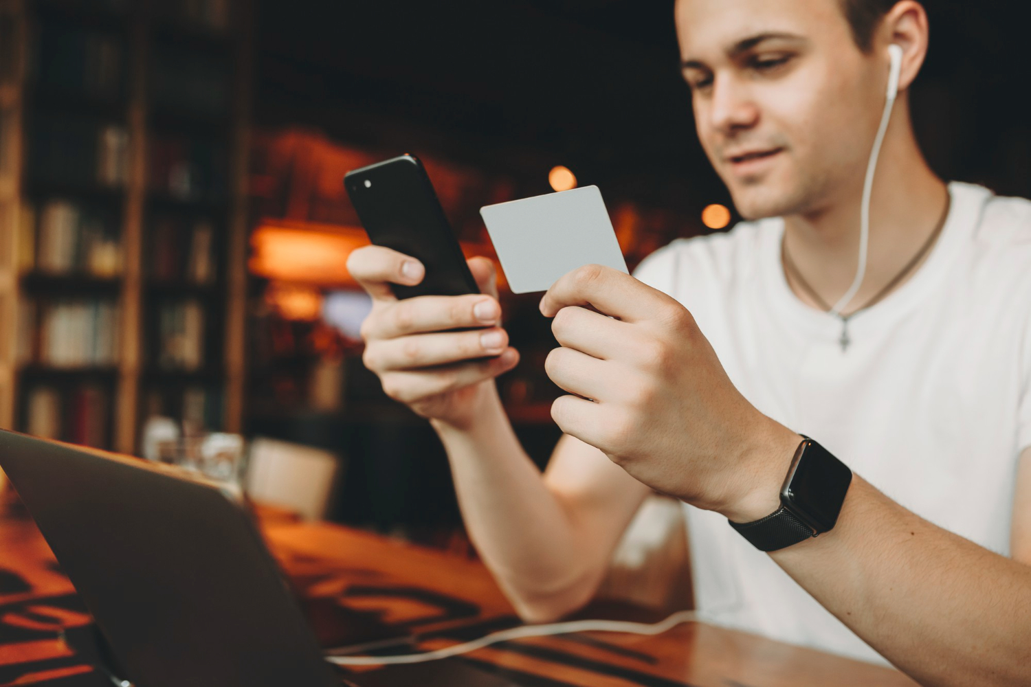 man in headphones holding card and phone